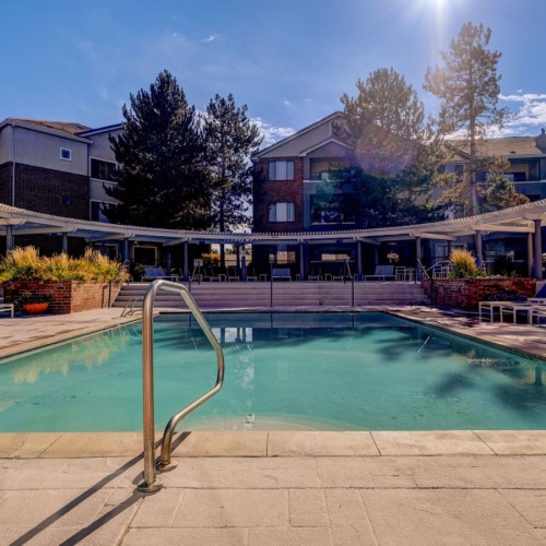 Relax and unwind poolside a swimming pool with a building in the background
