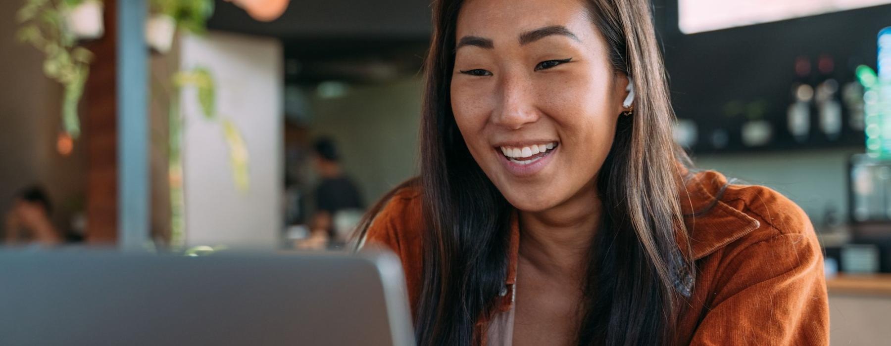 a woman smiling while working on laptop